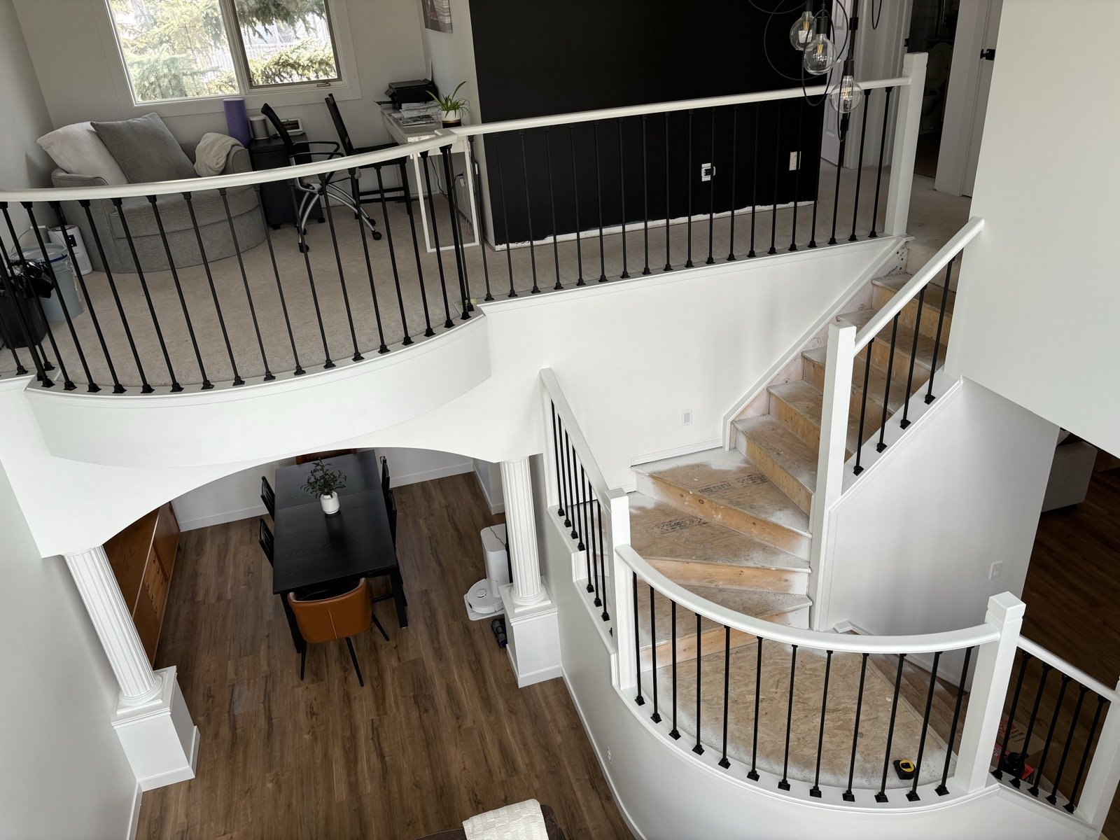 Custom curved staircase with white risers and black wrought-iron spindles